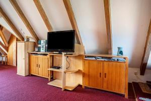 a tv on a wooden stand in a room at Ferienatelier im Haus Ginkgo in Zempow