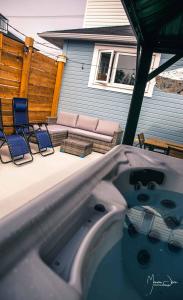 a hot tub in a backyard with chairs and a patio at Spa & Pool Table - Le Parvis in Trois-Pistoles