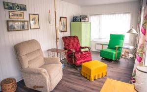 a living room with two chairs and a green refrigerator at Spa & Pool Table - Le Parvis in Trois-Pistoles
