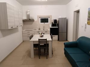 a kitchen with a table and a blue couch at villa mastroronzo in San Michele Salentino