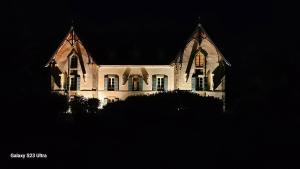 a large white building with windows at night at Domaine du Corgenay in Fleuriel +12 photos