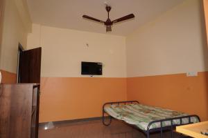 a room with a bed and a ceiling fan at Saradha paradise in Puducherry