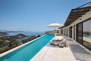 an infinity pool with a view of the ocean from a house at Villa Symposium Infinity in Sivota +29 photos