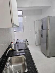 a kitchen with a sink and a refrigerator at Residencial Dois58 in Niterói +3 photos
