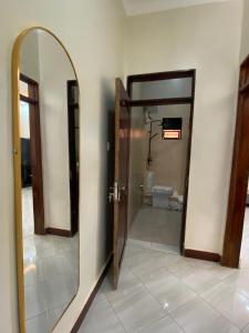 an open bathroom with a mirror and a toilet at Kira Garden Villas in Jinja