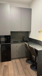 a kitchen with white cabinets and a table and chairs at Unirii Residence in Cluj-Napoca