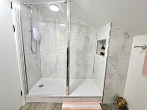 a shower with a glass door in a bathroom at One Bed Holiday Home in the Heart of Inverness in Inverness