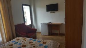 a room with a chair a table and a television at Guest house Ak Keme in Bosteri