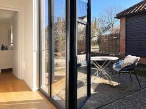a sliding glass door with a table and a chair at Polly's Yard in Dennington