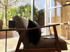 a chair with a pillow sitting next to a table at Polly's Yard in Dennington