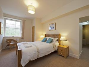 a bedroom with a bed and a chair and a window at The Sergeants Quarters, Golden Hill Fort in Freshwater