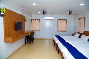 a hospital room with two beds and a tv at SR Residency in Chennai