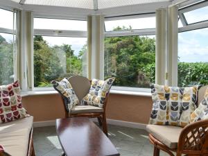 a room with windows with chairs and a table at Preswylfa in Llanddona