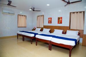 two twin beds in a room with two windows at SR Residency in Chennai