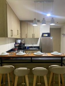 a kitchen with a table with chairs and a counter top at Cozy Room in Modern Paraaque Condo with 2 Bedrooms in Manila