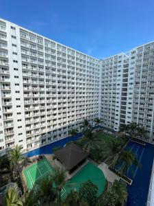 a large apartment building with a tennis court in front of it at Cozy Room in Modern Paraaque Condo with 2 Bedrooms in Manila