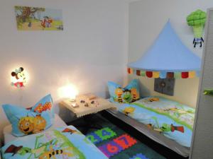 a bedroom with two twin beds and a toy house at Charmantes Ferienhaus Storchenblick in Kremmen