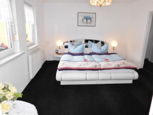 a bedroom with a large white bed with blue pillows at Charmantes Ferienhaus Storchenblick in Kremmen