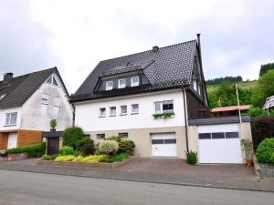 a white house with a black roof at Graceful Apartment in Velmede with Garden in Bestwig +32 photos