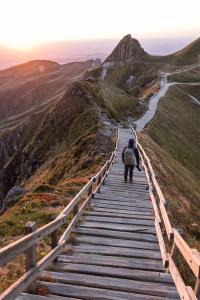 eine Person, die einen Holzpfad auf einem Berg hinuntergeht in der Unterkunft Escapade nature et bien-être in Royat