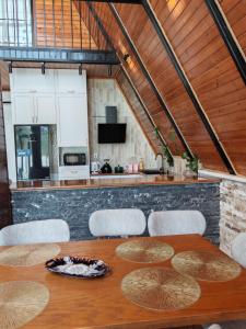 a dining room table with chairs and a kitchen at Huzoor Aframe Gabala in Gabala