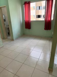an empty room with red curtains and a tiled floor at Apartamento COP 30 soure in Marituba