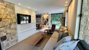 テレゾポリスにあるCasa 05 Vale Boa Vista - Refúgio Moderno em Condomínio Exclusivoのソファとテレビのあるリビングルーム +36枚の写真
