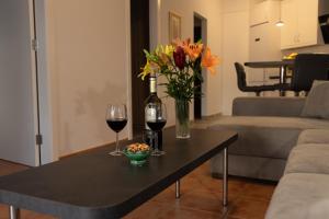a table with two glasses of wine and a vase of flowers at Infinity View in La Matanza de Acentejo