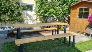 two wooden benches sitting in the grass next to a building at apartment77 in Bad Ischl