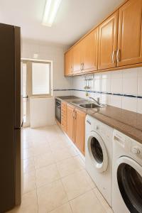a kitchen with a washer and dryer in it at 10 min walk to Rocha Beach in Portimão