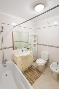 a bathroom with a tub and a toilet and a sink at 10 min walk to Rocha Beach in Portimão