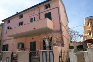 a pink building with a balcony on top of it at Giacomo Home in Marina di Cecina