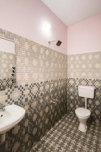 a bathroom with a toilet and a sink at Neon Nirvana in Varkala