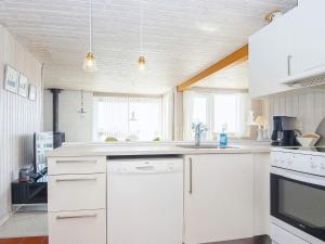 a kitchen with white cabinets and a sink at 6 person holiday home in Juelsminde-By Traum in Sønderby