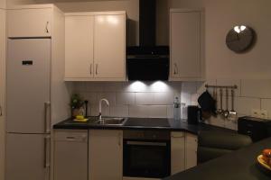 a kitchen with white cabinets and a sink and a refrigerator at Infinity View in La Matanza de Acentejo