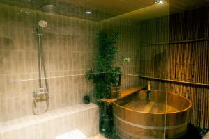 a bathroom with a wooden tub and a shower at Hakotel in Bang Rak +6 photos