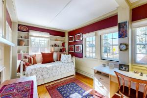 a bedroom with a bed and a desk and windows at Water Street Retreat in Sandwich