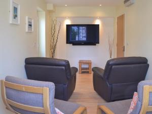 a waiting room with two chairs and a flat screen tv at North Shore in Crantock +10 photos