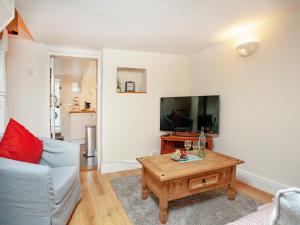 ein Wohnzimmer mit Sofa und Fernseher in der Unterkunft Otters Cottage in Ottery Saint Mary