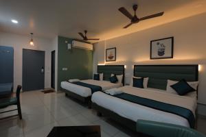 a bedroom with two beds and a ceiling fan at The Lotus Park in Srikalahasti