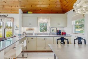 eine Küche mit weißen Schränken und einer Holzdecke in der Unterkunft Blue Sky Cottage in South Thomaston + 13 Fotos