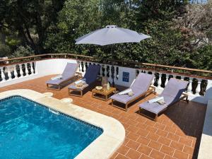 una piscina con sedie e ombrellone accanto ad essa di La FINCAD4 entre plages et Forêt a Son Parc