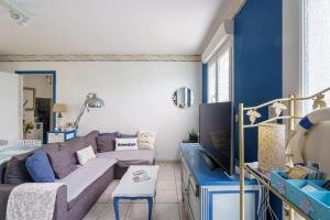 ein Wohnzimmer mit einer grauen Couch und blauen Wänden in der Unterkunft Ty Provans e Breizh - Maison pour 12p in Primelin