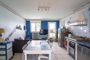 eine Küche mit einer Couch und einem Tisch in einem Zimmer in der Unterkunft Ty Provans e Breizh - Maison pour 12p in Primelin