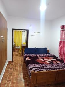 a bedroom with two beds and a hallway with a table at Osprey individual Cottage in Ooty
