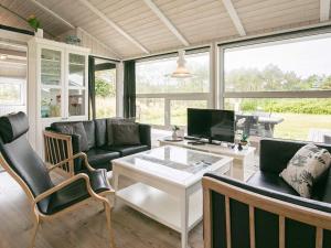 a living room with a couch and a table at 8 person holiday home in Løkken in Løkken +14 photos