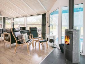 a living room with a fireplace and a table and chairs at 8 person holiday home in Løkken in Løkken
