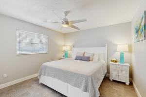 ein Schlafzimmer mit einem weißen Bett und einem Deckenventilator in der Unterkunft Snow We're Not in Englewood + 15 Fotos