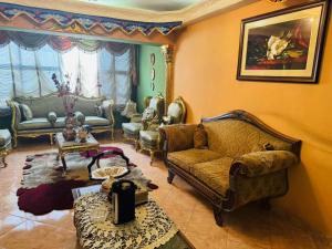 Una sala de estar con un sofá y sillas y una mesa. en Cairo 1890, en El Cairo