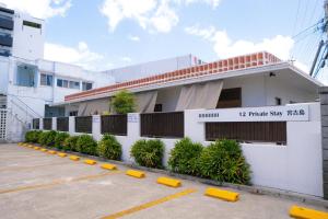 a building with a parking lot in front of it at 12Private Stay宮古島 in Miyako Island